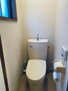 大泉学園ヴィラ في Katayama: حمام مع مرحاض أبيض في الغرفة