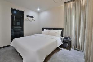 釜山的住宿－Busan Platinum Hotel Nampo，卧室设有一张白色大床和一扇窗户。