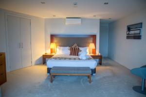 um quarto com uma cama grande com 2 mesas e 2 candeeiros em The Waterfront Suites - Heritage Collection em Paihia