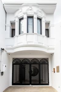 a white house with a black gate at The Elements Boutique House in Phuket Town