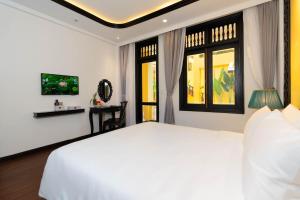 a bedroom with a white bed and two windows at Oriental Boutique Hoi An in Hoi An