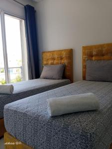 two beds sitting next to each other in a bedroom at Appartemnt Essaouira welcome all in Essaouira