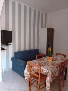 een woonkamer met een tafel en een blauwe bank bij Casa Vacanze EtnaMolù in Giarre