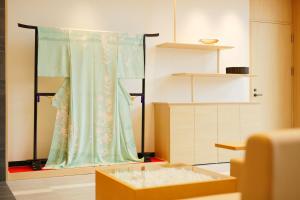 a dressing room with a curtain and a table at Kanazawa Sainoniwa Hotel in Kanazawa