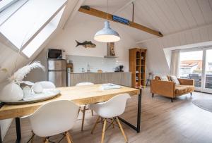 Una cocina y un comedor con mesa y sillas. en Bodhi Beach House, en Egmond aan Zee