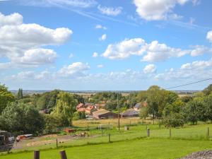 un champ avec des maisons et un ciel bleu avec des nuages dans l'établissement Hillcrest Caravan - Uk44798, à Hemswell