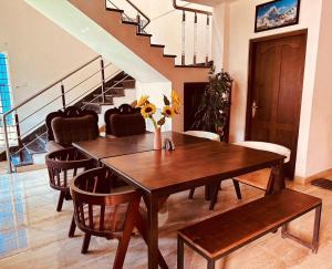 a dining room with a wooden table and chairs at Fortis Rooms in Cochin