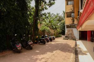 una fila de motonetas estacionadas al lado de un edificio en Mossy - Aesthetic 2BHK Apartment - Vagator, Goa By StayMonkey, en Vagator