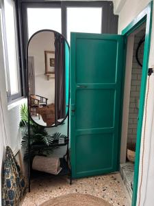 eine grüne Tür und ein Spiegel im Zimmer in der Unterkunft N•73. Stylish boutique home in Tursi Basilicata in Tursi