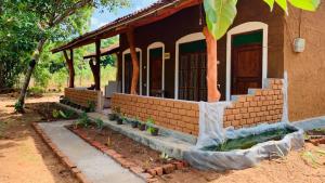 Sigiriya Chena Villa في سيجيريا: منزل من الطوب مع شرفة وجدار من الطوب