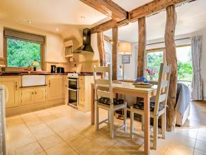 a kitchen with a table and chairs in a room at The Cottage Barn in Botesdale
