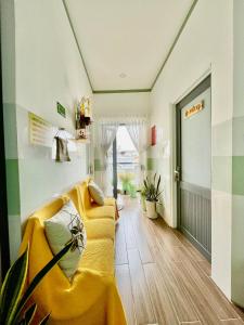 un pasillo con un sofá amarillo en una habitación en Leo's Homestay Phan Rang en Phan Rang