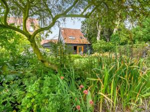 a small house in the middle of a garden at The Cottage Barn in Botesdale