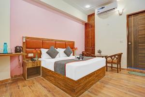 a hotel room with a bed and a table at OYO Flagship 74435 Hotel Sharma in Greater Noida
