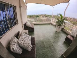 a balcony with two couches and an umbrella at Hostal Casa del Sol in Santa Marta