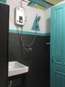 La salle de bains est pourvue d'un lavabo et d'un sèche-cheveux sur le mur. dans l'établissement Bamboo Hostel, à Thakhek