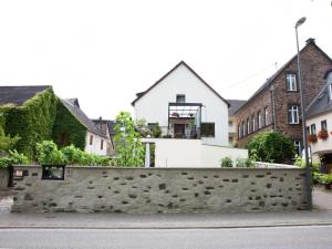 a house behind a stone wall in a street at Pleasant Apartment in Ernst bei Cochem with Garden in Ernst