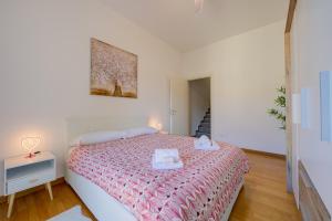 a bedroom with a bed with a pink comforter at Residenza Castello - Happy Rentals in Mendrisio