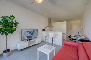 a living room with a red couch and a kitchen at Residenza Castello - Happy Rentals in Mendrisio