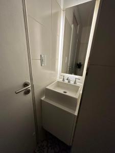 a white bathroom with a sink and a mirror at Avenida Colon Trendy APT in Mendoza