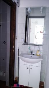 a bathroom with a white sink and a window at Apartments Vesna in Ribarica +12 photos