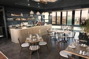 a restaurant with tables and chairs and a bar at Menlyn Trilogy - 2 Bedroom & Great Views - No Loadshedding in Pretoria