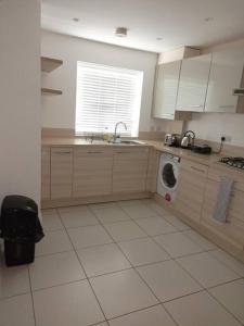 a kitchen with a sink and a washing machine at Stansted Airport Serviced Accommodation x DM for Weekly x Monthly Deals by D6ten Homes Ltd in Takeley