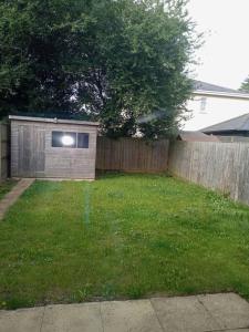 un pequeño cobertizo en un patio junto a una valla en Stansted Airport Serviced Accommodation x DM for Weekly x Monthly Deals by D6ten Homes Ltd en Takeley