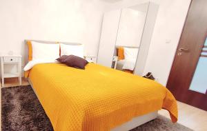 a bedroom with a yellow blanket on a bed at R&B Guest House in Câmpulung Moldovenesc