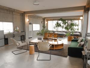 ein Wohnzimmer mit einem Sofa, einem Tisch und Stühlen in der Unterkunft Bstudio in Wakayama