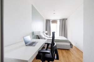 a bedroom with a desk with a laptop and a bed at Lovely Apartment in Marina Tower - 10min to City Center in Vienna