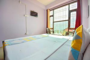 1 dormitorio con cama y ventana grande en Flagship The Alpine Homes en Solan