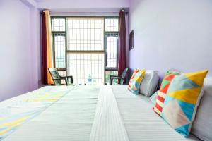 1 cama grande con almohadas coloridas en una habitación en Flagship The Alpine Homes en Solan
