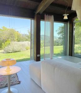 1 dormitorio con sofá blanco y ventana grande en Agriturismo "Le Cannelle" spa & day wellness, en Fossombrone
