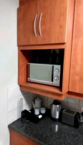 a microwave in a wooden cabinet in a kitchen at Gautrain Hatfield Lovely Studio in Pretoria