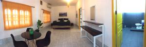 Bamboo Hostel في ثاكيك: غرفة معيشة مع سرير وطاولة وكراسي