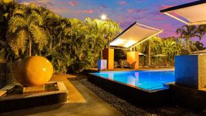 a house with a swimming pool in the yard at The Pearle of Cable Beach in Broome