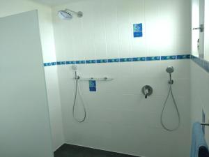uma casa de banho com chuveiro e 2 mangueiras em Jochen's Haus - Zimmer & Bad em Siershahn