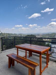 una mesa y bancos en un balcón con vistas en Sky Heaven Hotel, en Kandy