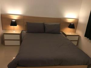 1 dormitorio con 1 cama grande y 2 mesitas de noche en Great location accommodation en St Paul's Bay