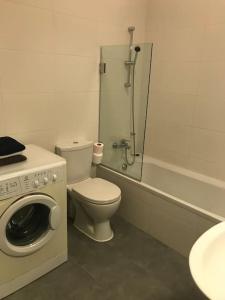 a bathroom with a toilet and a washing machine at Great location accommodation in St Paul's Bay