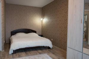 1 dormitorio con 1 cama con manta blanca en Академіка Корольова 20 1, en Cherkasy