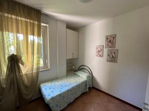 Schlafzimmer mit einem Bett und einem Fenster in der Unterkunft Casa Alice Garda in Garda