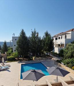 una piscina con ombrelloni in un resort di Villa Penelope a Douliana