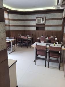 a dining room with tables and chairs in a restaurant at Hotel Ranjeet in Agra