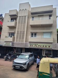 une voiture garée devant un bâtiment dans l'établissement Hotel Ranjeet, à Agra