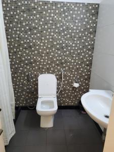 ein Badezimmer mit einem weißen WC und einem Waschbecken in der Unterkunft Hotel Ranjeet in Agra
