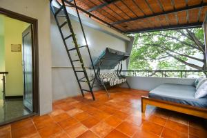 a room with a ladder and a bed on a balcony at HomeSlice Manor in Bangalore
