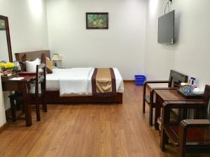 1 dormitorio con 1 cama, escritorio y TV en Khách Sạn Sông Hiến en Cao Bằng