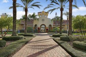 un bâtiment avec des palmiers et une passerelle dans l'établissement Vista Cay Resort by Millenium at Universal Blvd., à Orlando